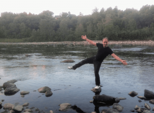 Paul balancing on a stone in river