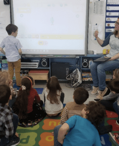 Student learning about scratch jr blocks on whiteboard